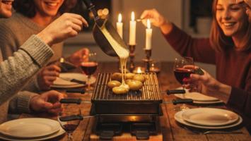 Festligt raclette-middagsopstilling med smeltet ost og varm stemning ved det nordiske spisebord